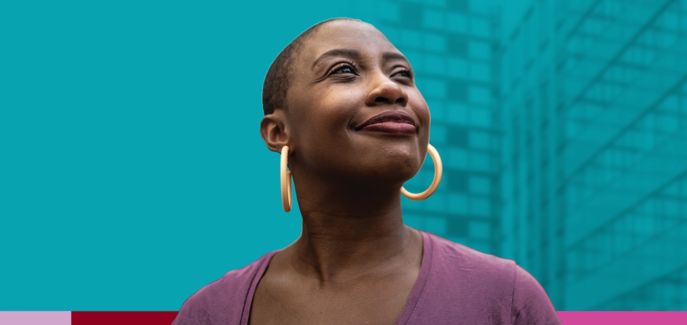 A woman smiling and looking upward against a blue background