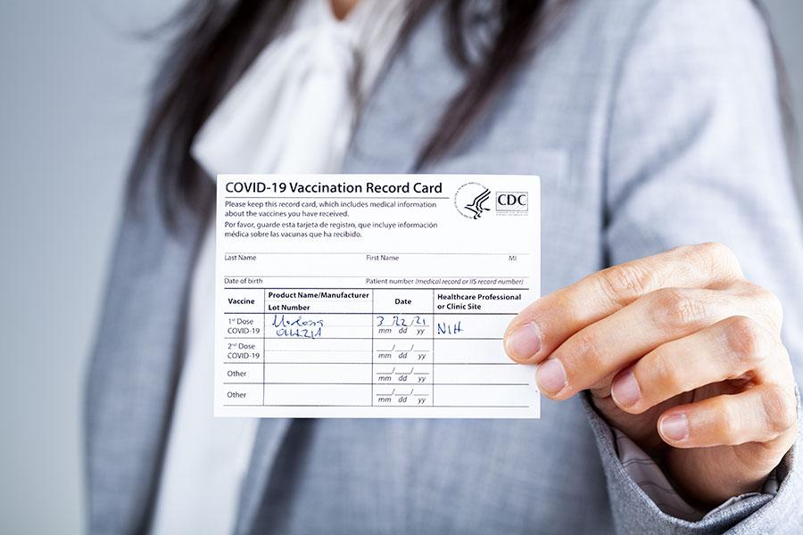 Woman holding Covid-19 vaccine card