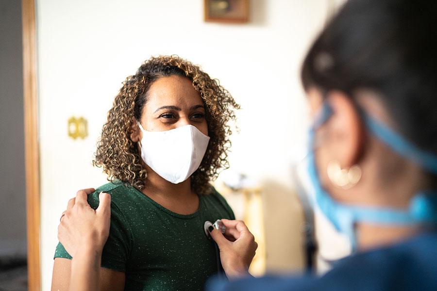 Doctor checking patient's heart with stethoscope