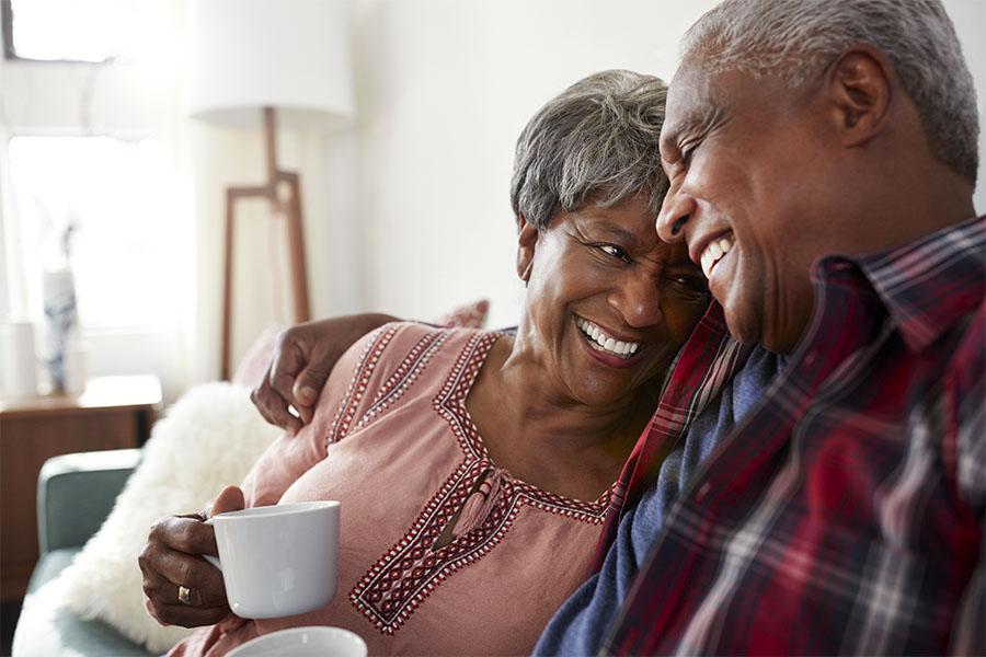 Senior couple sitting on couch at home