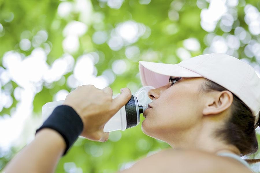 Woman drinking water bottle outside