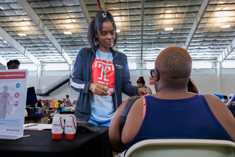 Community Health worker Antionett McNear administers a free health screening to a community member.