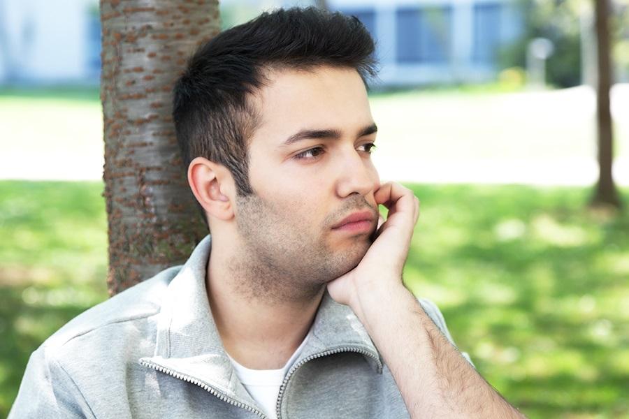 Young student in park depressed